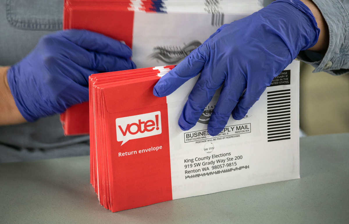 An election worker wearing protective gloves sorts through mailed-in ballots in the King County Elections ballot processing center on March 9, 2020, in Renton, Washington.