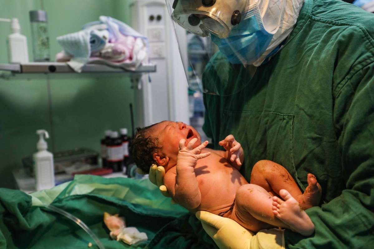 A medical staff member holds a newborn after a caesarean section at a gynaecology and obstetrics isolation ward for expectant mothers infected by the COVID-19 coronavirus in Xiehe hospital in Wuhan, in China's central Hubei province, March 7, 2020.