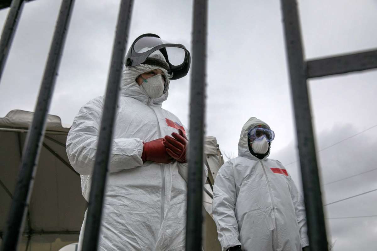 Health workers dressed in personal protective equipment await new patients at a drive-thru coronavirus testing station at Cummings Park on March 23, 2020, in Stamford, Connecticut.