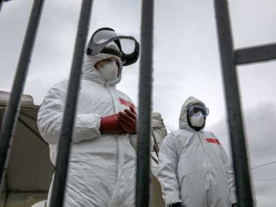 Health workers dressed in personal protective equipment await new patients at a drive-thru coronavirus testing station at Cummings Park on March 23, 2020, in Stamford, Connecticut.