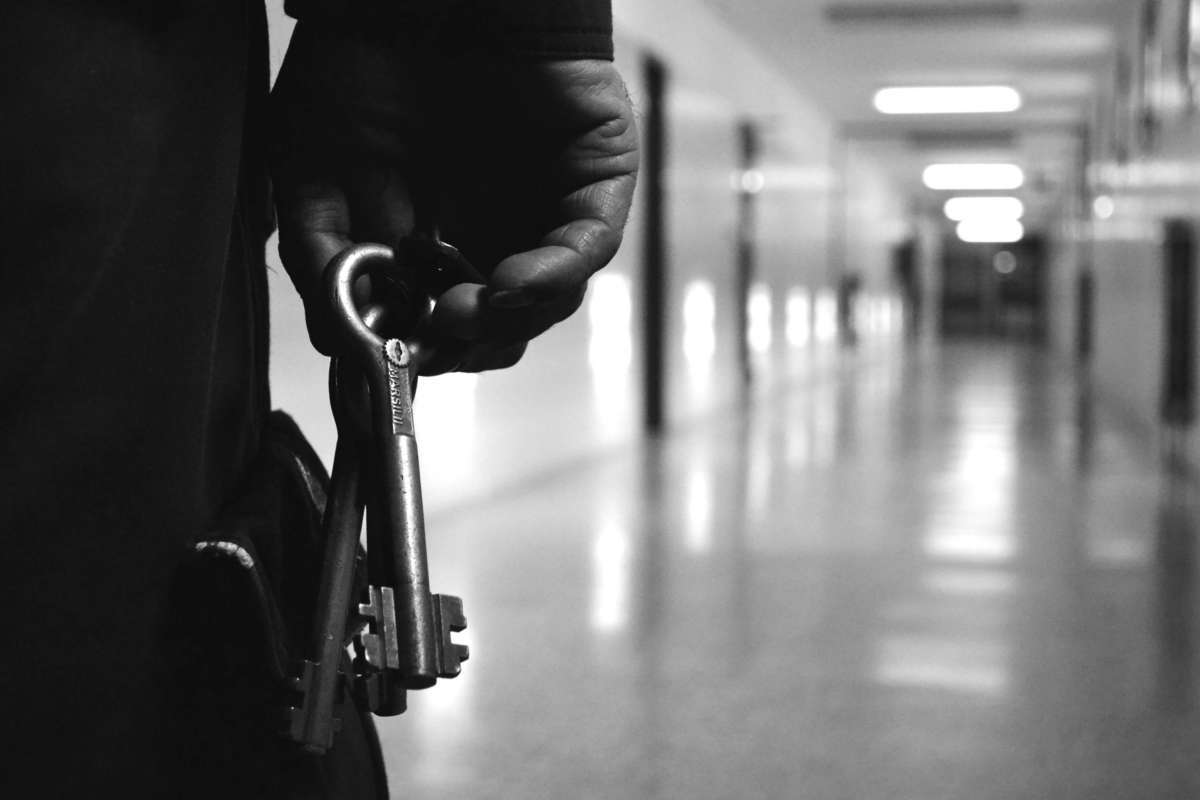 Prison guard holds keys in prison hallway