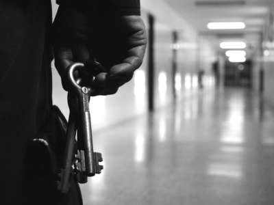 Prison guard holds keys in prison hallway