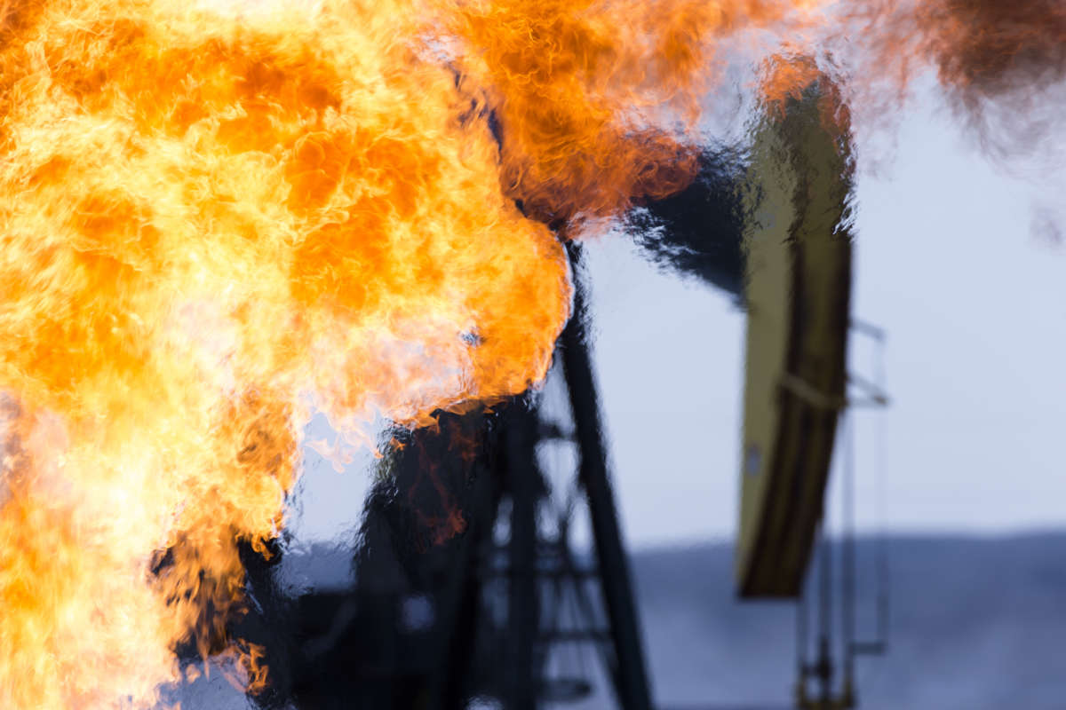 A pumpjack with fire in the foreground