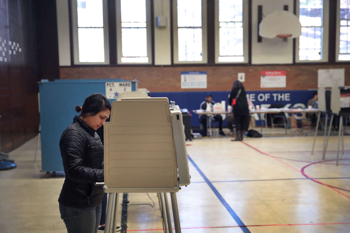 A woman stands at a voting booth