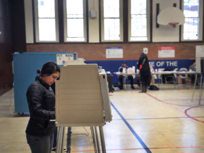 A woman stands at a voting booth