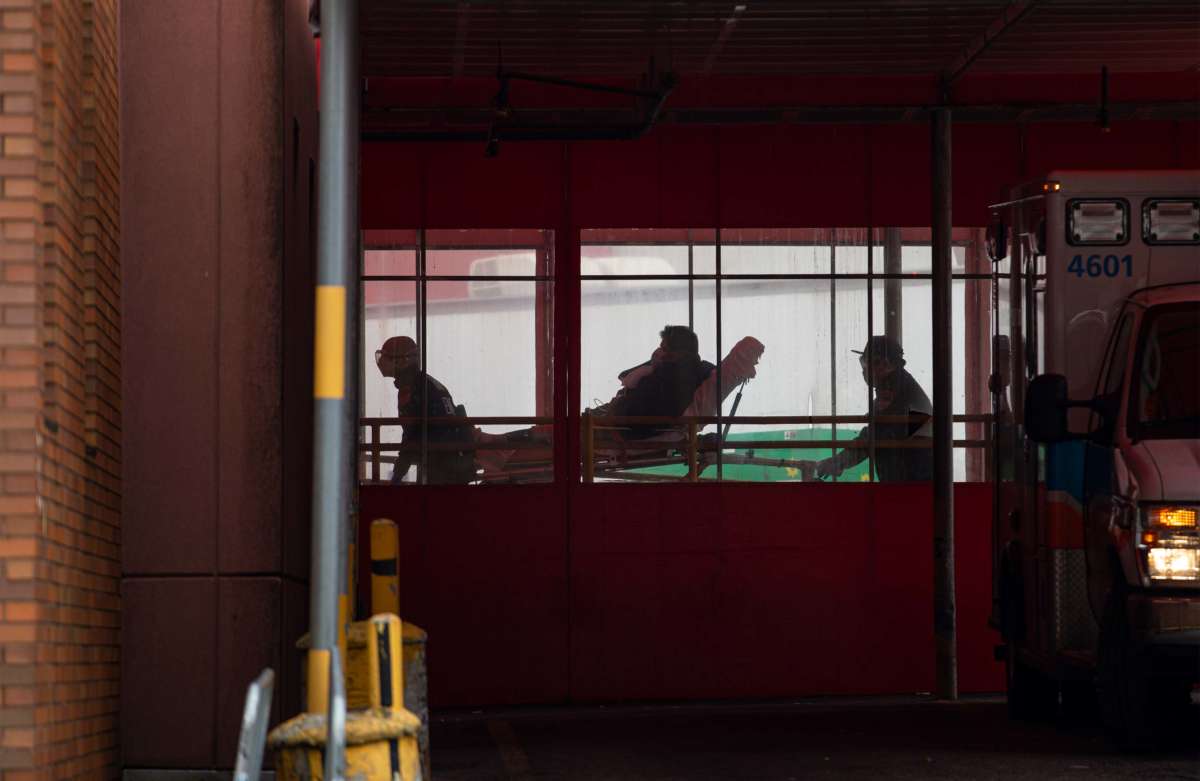 Two members of the Fire Department of New York's Emergency Medical Team wheel in a patient with coronavirus to the Elmhurst Hospital Center in the Queens borough of New York City on March 30, 2020.