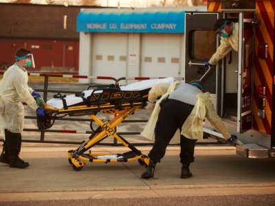 First responders from IU Health Bloomington hospital pick up a person describing COVID-19 symptoms in Bloomington, Indiana, March 23, 2020.