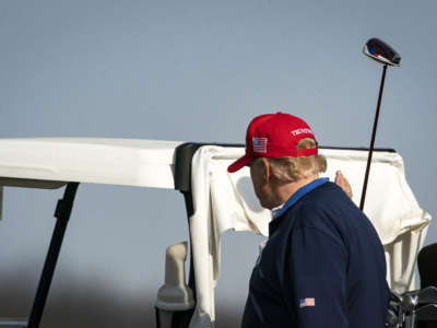 Donald Trump walks back to a golf cart