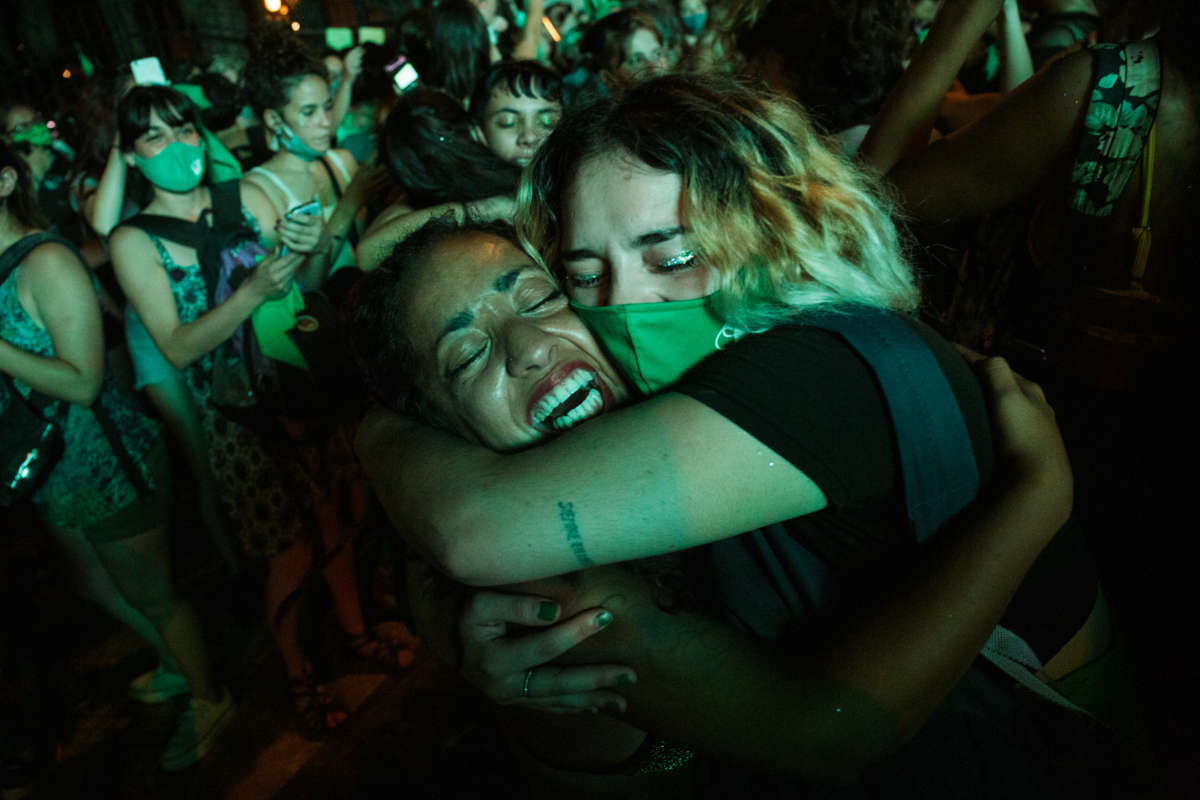Green-clad women cheer and embrace eachother during a rally
