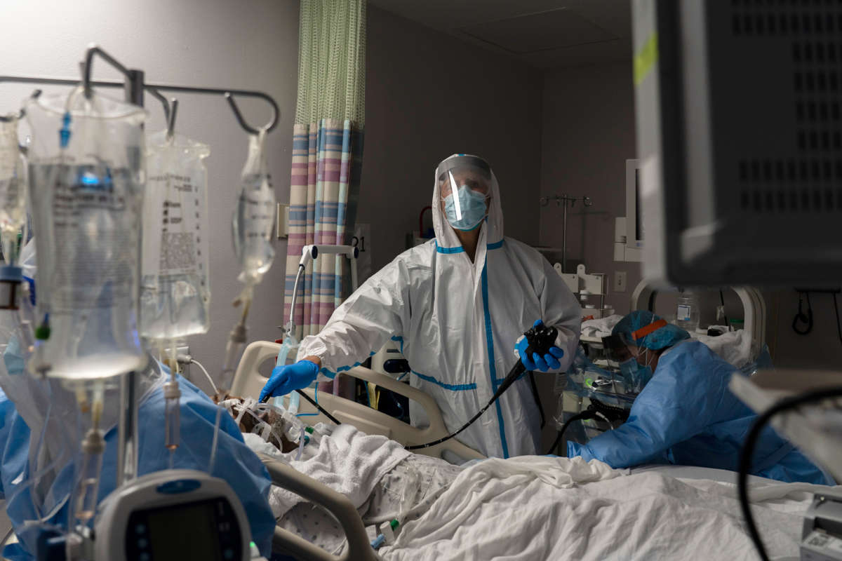 A doctor looks at displays while treating a patient