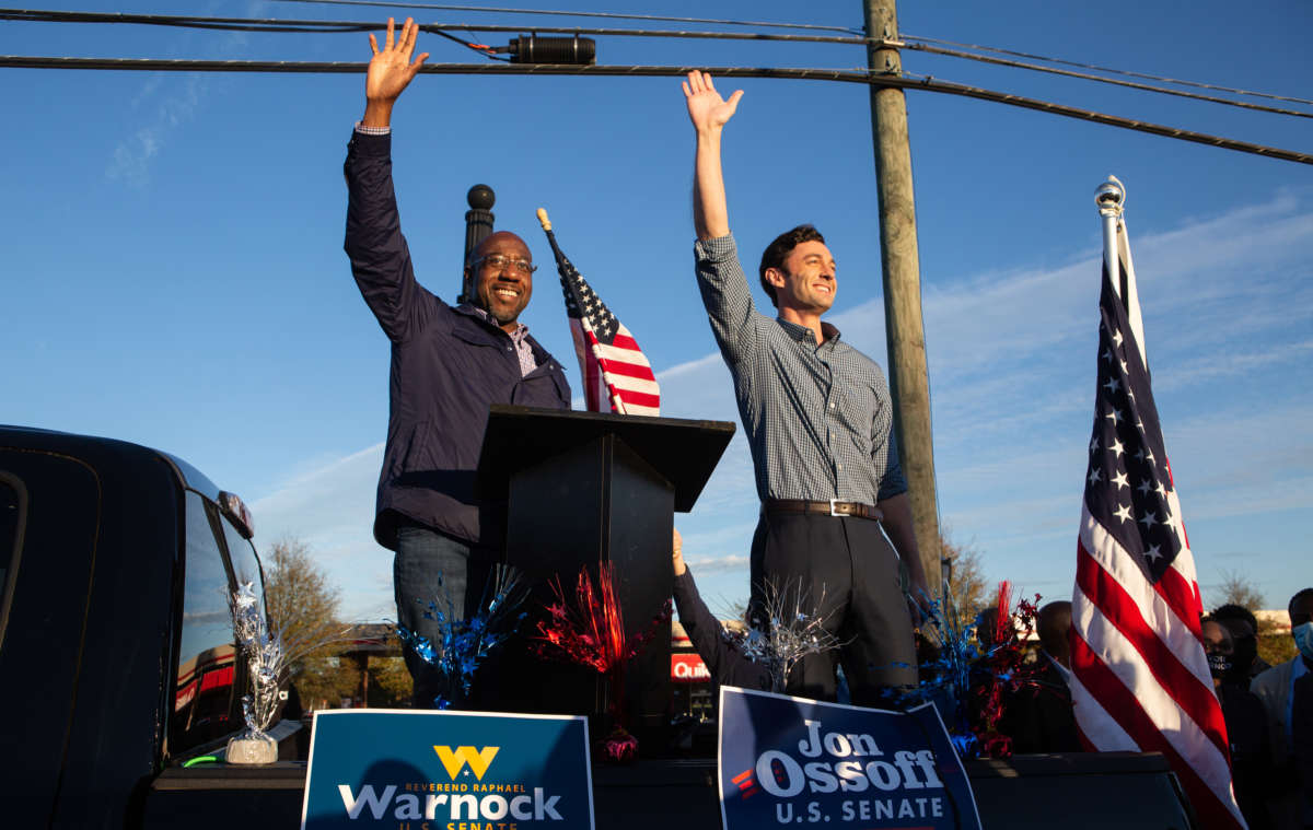 Democratic Senate candidates Raphael Warnock (left) and Jon Ossoff of Georgia wave to supporters during a rally on November 15, 2020, in Marietta, Georgia.