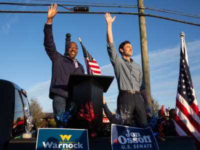 Democratic Senate candidates Raphael Warnock (left) and Jon Ossoff of Georgia wave to supporters during a rally on November 15, 2020, in Marietta, Georgia.