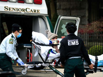 Emergency Medical Service workers unload a patient out of their ambulance at the Cobble Hill Health Center on April 18, 2020, in the Cobble Hill neighborhood of the Brooklyn borough of New York City.