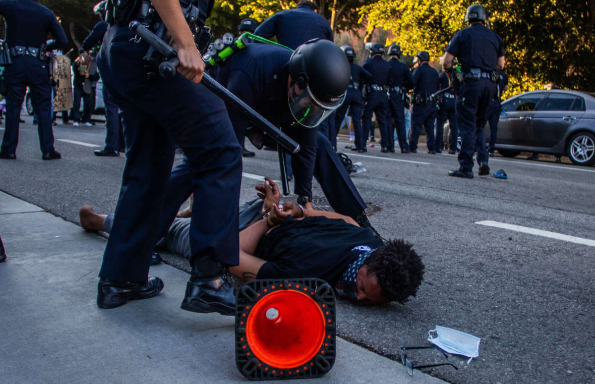 A police officer arrests a man in front of the U.S. Courthouse during a protest demanding justice for George Floyd, Breonna Taylor and in solidarity with Portland's protests, in Downtown Los Angeles, California, on July 25, 2020.