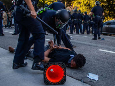 A police officer arrests a man in front of the U.S. Courthouse during a protest demanding justice for George Floyd, Breonna Taylor and in solidarity with Portland's protests, in Downtown Los Angeles, California, on July 25, 2020.