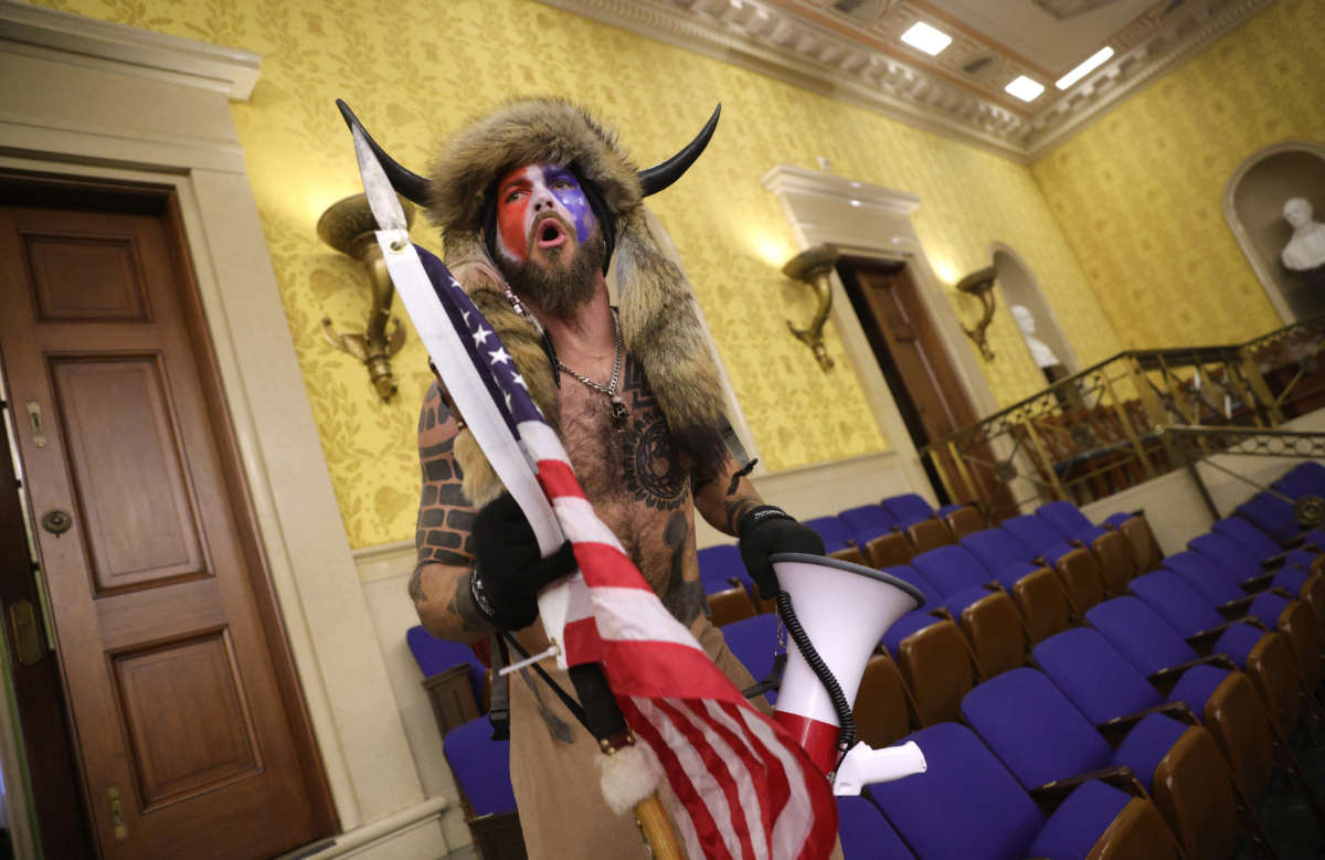 A man identified as Jacob Anthony Chansley, who also goes by the name “QAnon Shaman," screams "Freedom" inside the Senate chamber after the U.S. Capitol was breached by a mob during a joint session of Congress on January 6, 2021, in Washington, D.C.