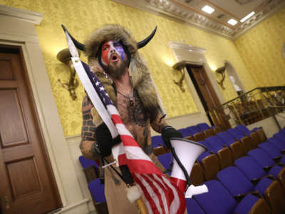 A man identified as Jacob Anthony Chansley, who also goes by the name “QAnon Shaman," screams "Freedom" inside the Senate chamber after the U.S. Capitol was breached by a mob during a joint session of Congress on January 6, 2021, in Washington, D.C.