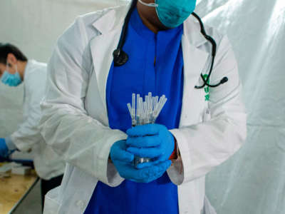 A health worker carries syringes to administer Pfizer Covid-19 vaccines at the opening of a new vaccination site at Corsi Houses in Harlem, New York, on January 15, 2021.