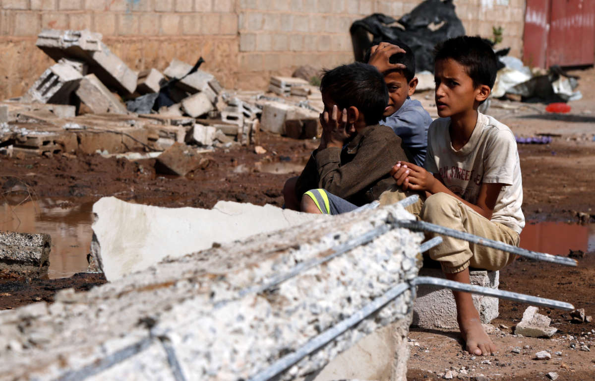 Children sit on the rubble of a warehouse after it was hit by airstrikes in Sanaa, Yemen, on July 2, 2020.