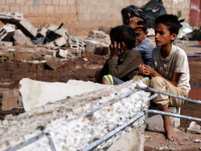 Children sit on the rubble of a warehouse after it was hit by airstrikes in Sanaa, Yemen, on July 2, 2020.