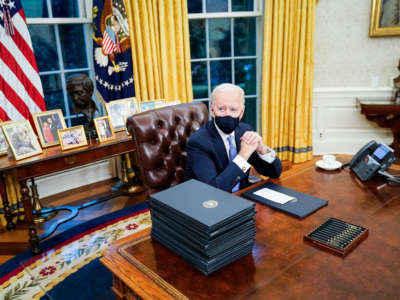 President Joe Biden at his desk in the Oval Office of the White House on January 20, 2021, in Washington, D.C.
