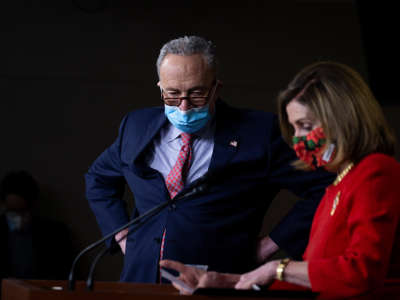 Then-Senate Minority Leader Chuck Schumer listens as Speaker of the House Nancy Pelosi speaks during a press conference on Capitol Hill on December 20, 2020, in Washington, D.C.