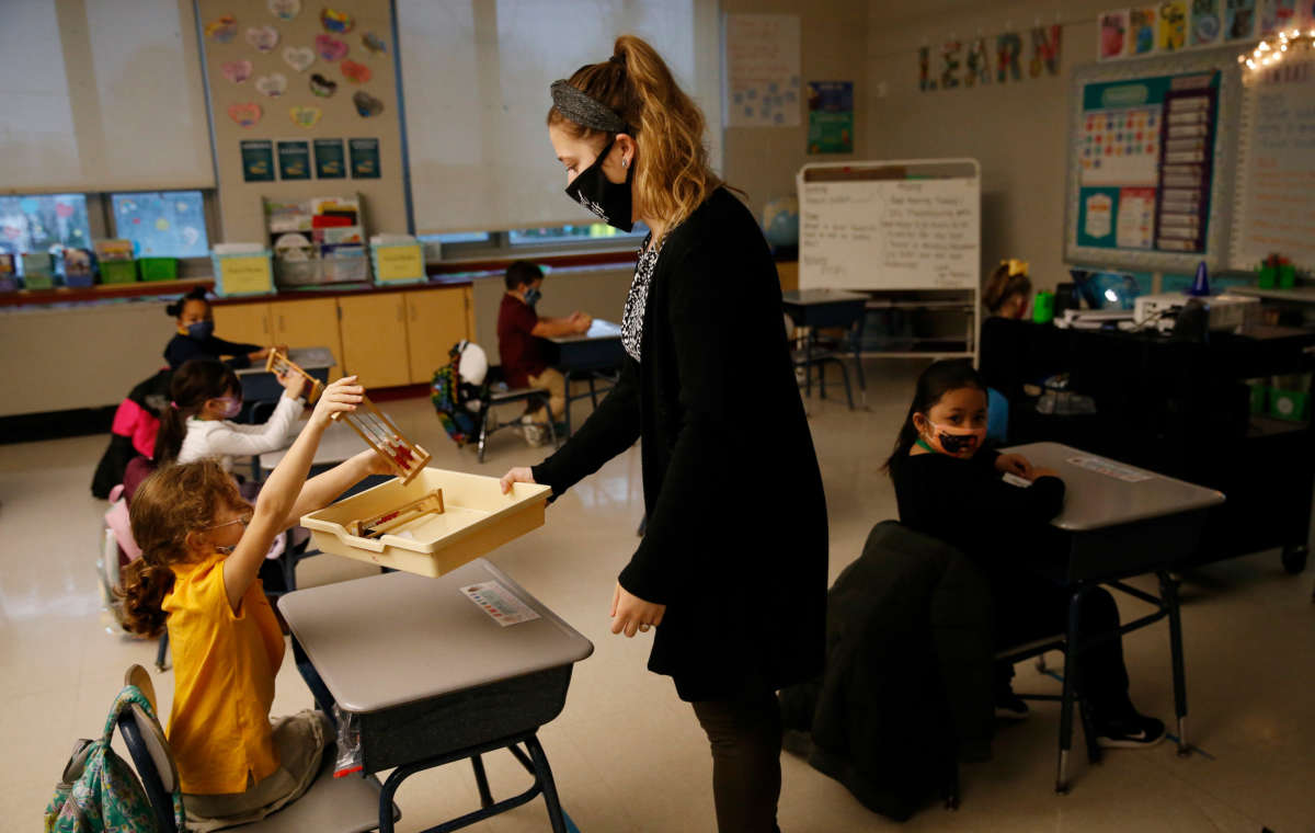 A teacher collects her students math racks after finishing a lesson with her first grade class at Mary L. Fonseca Elementary School in Fall River, Massachusetts, on November 23, 2020.