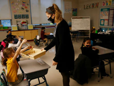 A teacher collects her students math racks after finishing a lesson with her first grade class at Mary L. Fonseca Elementary School in Fall River, Massachusetts, on November 23, 2020.