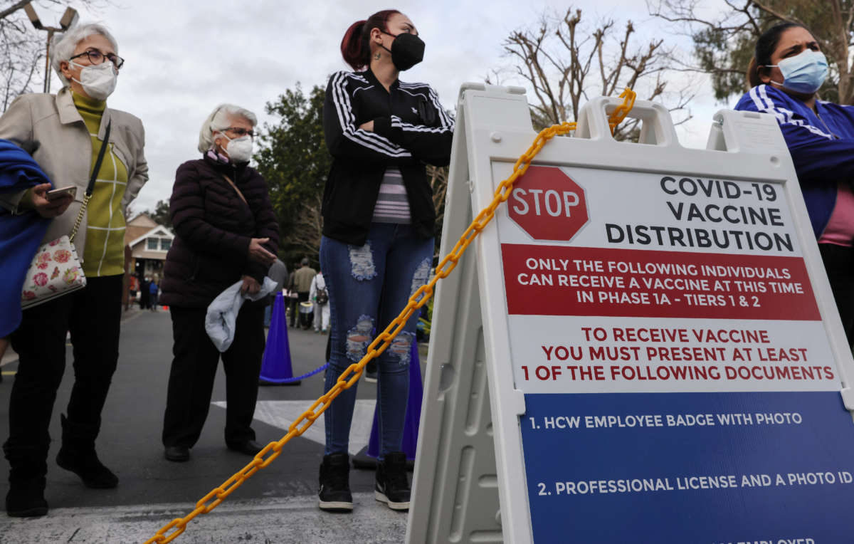 People wait outside a COVID-19 vaccine distribution center at the Kedren Community Health Center on January 28, 2021, in Los Angeles, California.