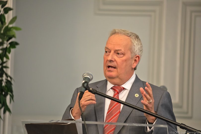 A man speaks into a microphone t a podium