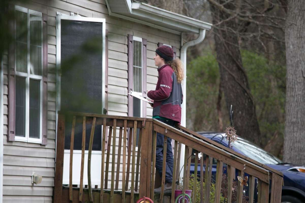 Aperson in a maroon shirt speaks to someone through their open door