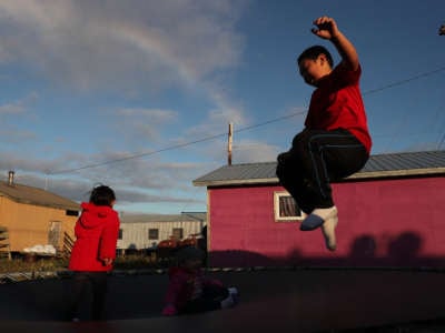 A child plays on a trampoline on September 10, 2019, in Kivalina, Alaska. Kivalina is situated at the very end of an eight-mile barrier reef located between a lagoon and the Chukchi Sea. The village is 83 miles above the Arctic circle.