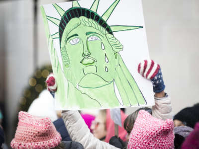 A marcher holds a sign that shows the Statue of Liberty with tears running down her face during the Women's March in the borough of Manhattan in NY on January 18, 2020.