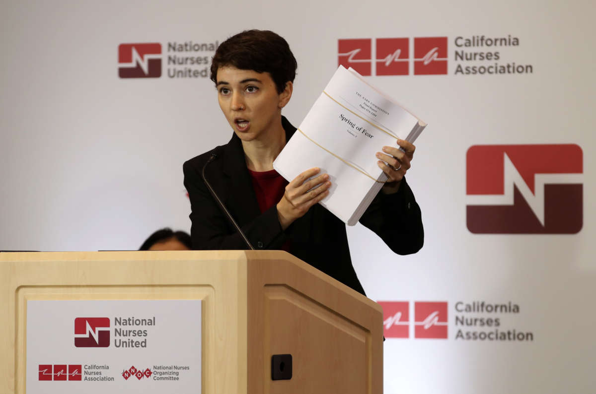 Jane Thomason, an industrial hygienist for National Nurses United, holds up a report about the SARS virus during a news conference with health care workers at the union's offices on March 5, 2020, in Oakland, California. The union held a news conference to express concerns that the Centers for Disease Control and Prevention is not doing enough to help protect and test health care workers who are exposed to patients with the COVID-19 virus.