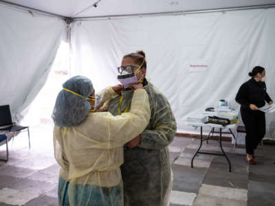 Nurses adjust protective masks inside a testing tent at St. Barnabas Hospital on March 20, 2020, in New York City.