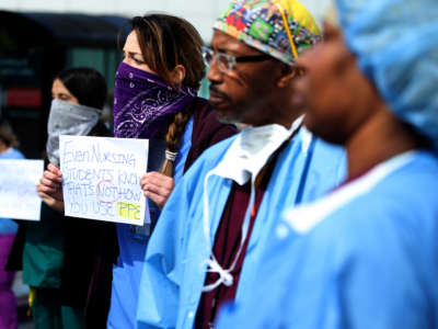 Alameda Health System nurses, doctors and workers hold signs during a protest in front of Highland Hospital on March 26, 2020, in Oakland, California.