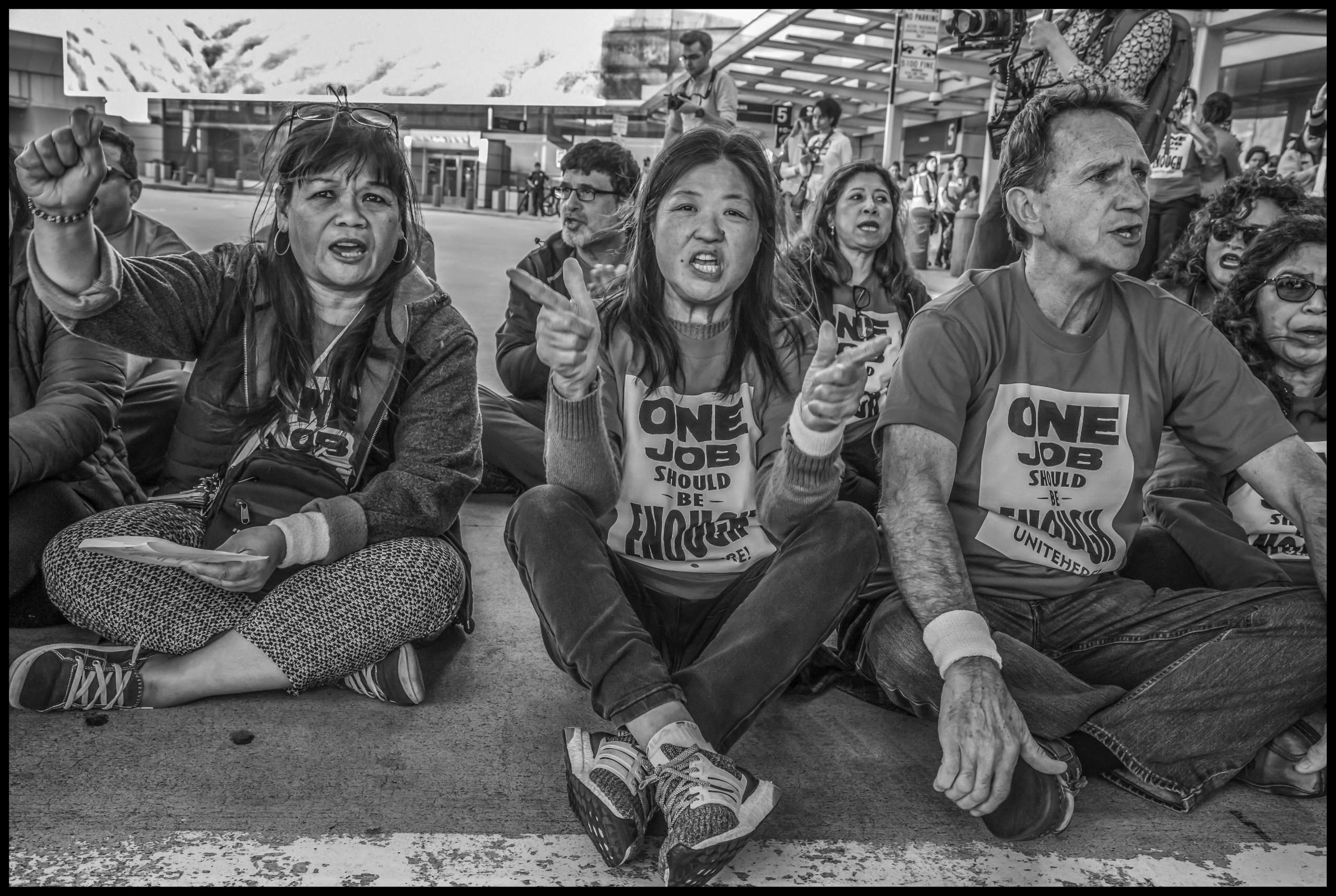 Tina Chen, Local 2 secretary-treasurer, sits in the roadway with other Local 2 members and supporters.