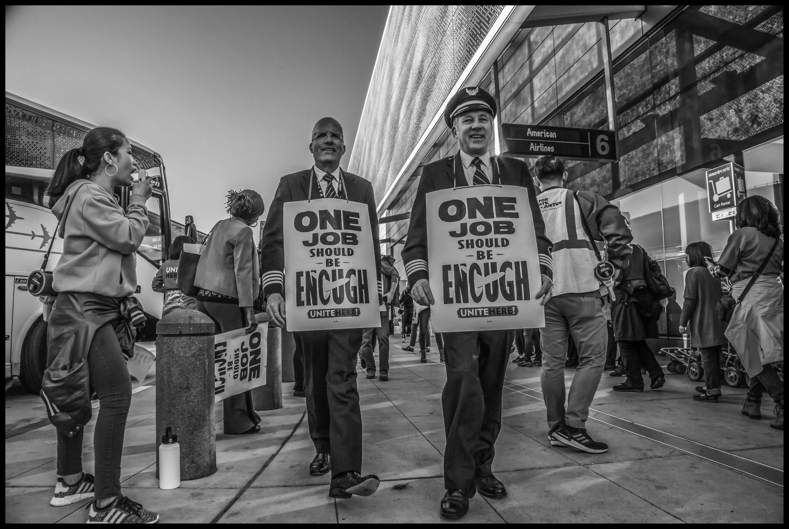 Pilots march with airlines food service workers outside the American Airlines terminal.
