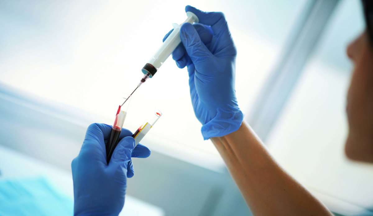 A nurse vills vials with a patient's blood for a test