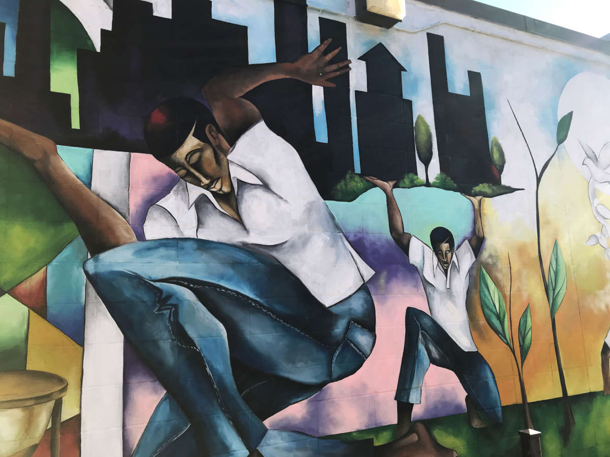 A mural by Samuel McCain depicts food production on a building at the Ida B. Wells Plaza.