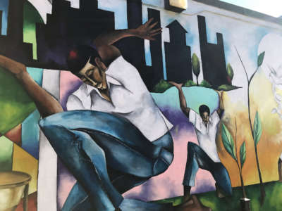 A mural by Samuel McCain depicts food production on a building at the Ida B. Wells Plaza.