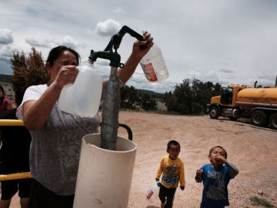 A woman, a member of the Navajo Nation, fills bottles of water at a public tap on June 5, 2019, in Thoreau, New Mexico.