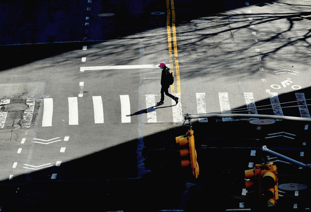 A person crosses the street on March 27, 2020, in New York City.