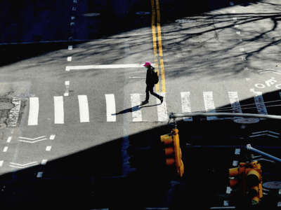 A person crosses the street on March 27, 2020, in New York City.