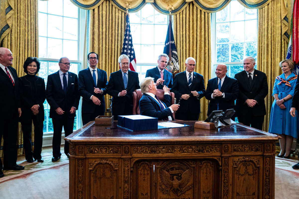 President Trump hands out pens during a bill signing ceremony for H.R. 748, the CARES Act, in the Oval Office of the White House on March 27, 2020, in Washington, D.C.