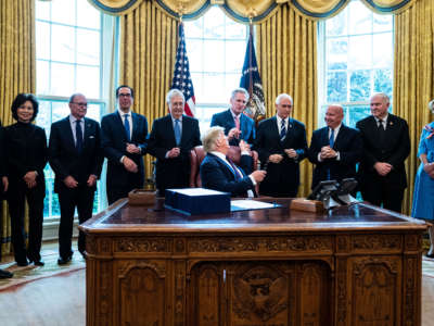 President Trump hands out pens during a bill signing ceremony for H.R. 748, the CARES Act, in the Oval Office of the White House on March 27, 2020, in Washington, D.C.