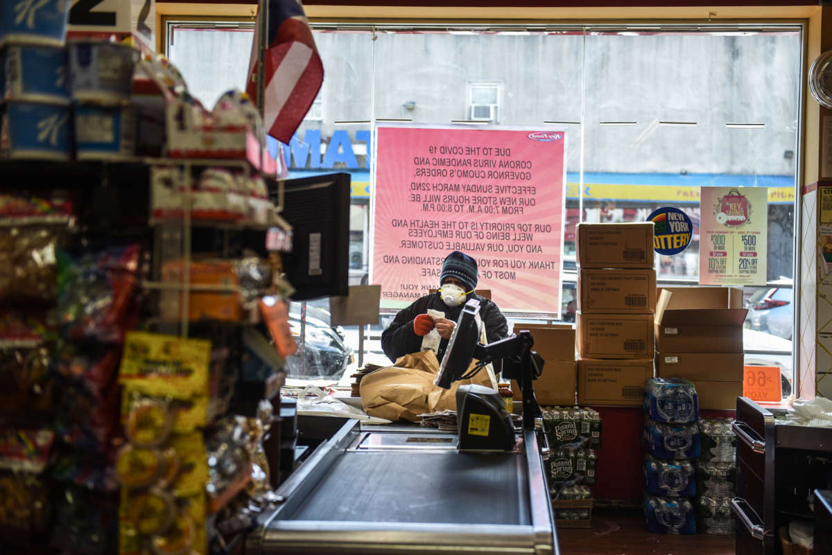A person wearing a protective mask looks at a grocery receipt while shopping in a grocery store in the Bushwick neighborhood of Brooklyn on April 2, 2020, in New York City.