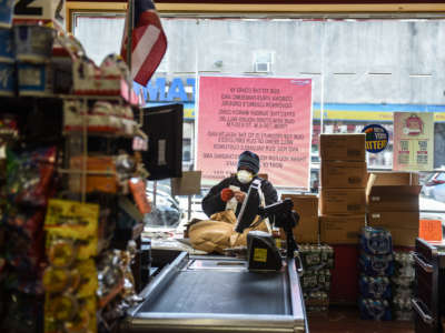 A person wearing a protective mask looks at a grocery receipt while shopping in a grocery store in the Bushwick neighborhood of Brooklyn on April 2, 2020, in New York City.
