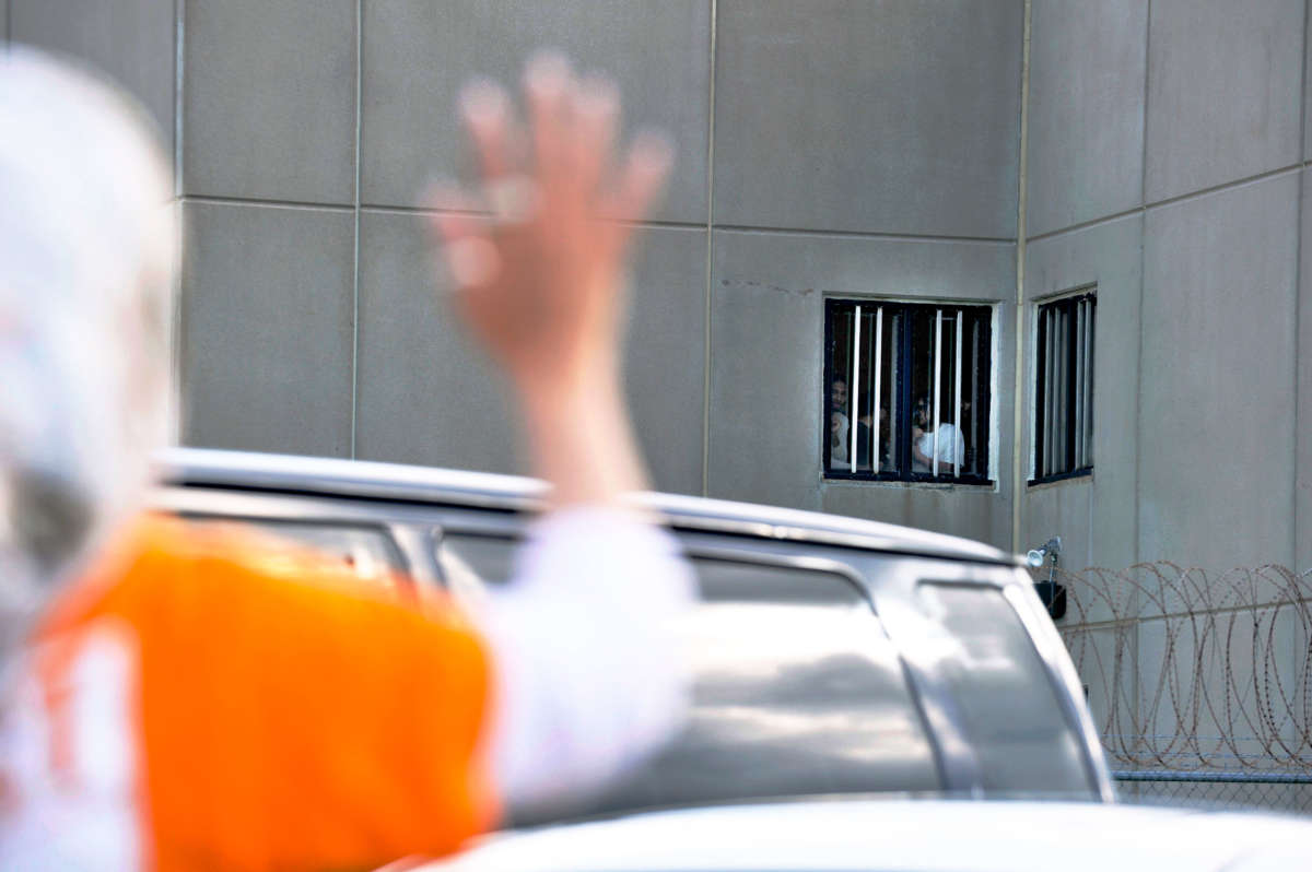 A women waves to detainees at the Strafford County Detention Center where ICE detainees are being held in Dover, New Hampshire, on August 24, 2019.