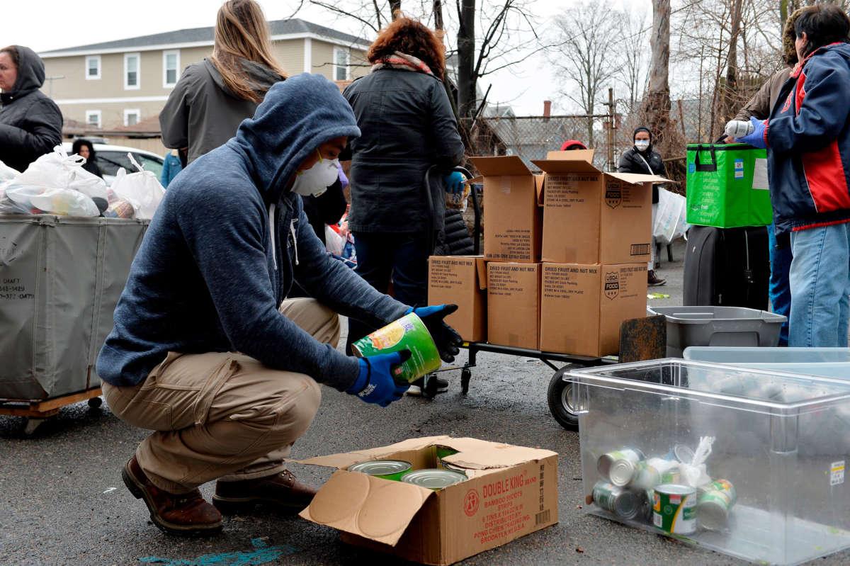 Volunteers hand out food and other goods to hundreds of people during the COVID-19 crisis in Everett, Massachusetts, on March 20, 2020.